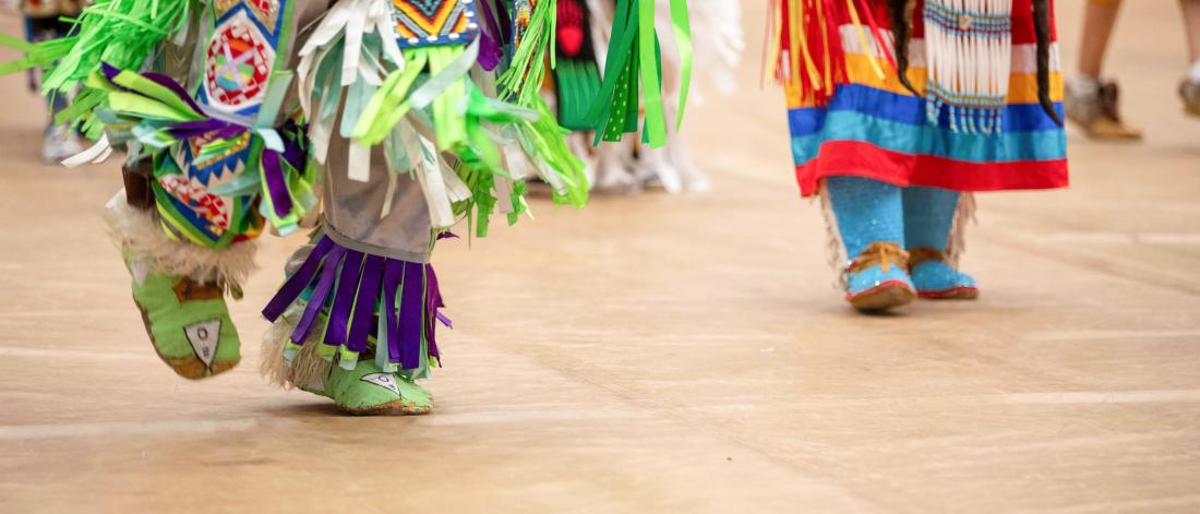 A dancer's feet are shown moving during a traditional graduation pow wow.