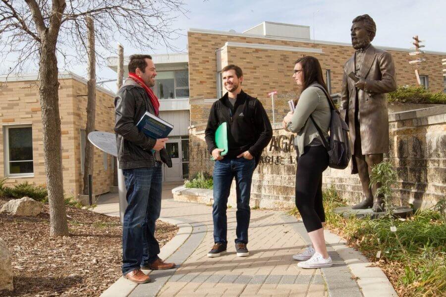 Students standing outside of Migizii Agamik, Bald Eagle Lodge.