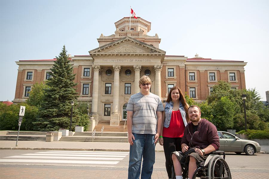 Three UM students in front of the UM administration building.
