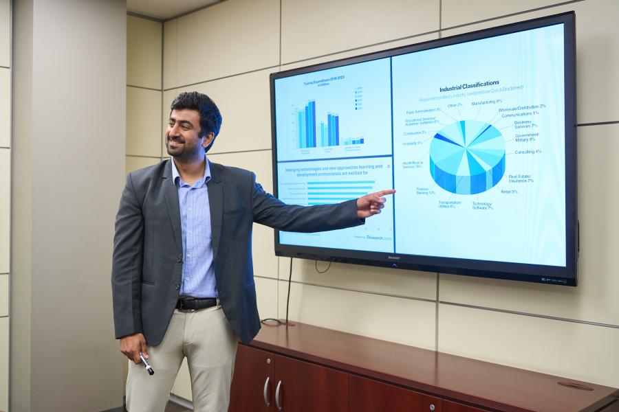 A post doctoral fellow presenting to a classroom.