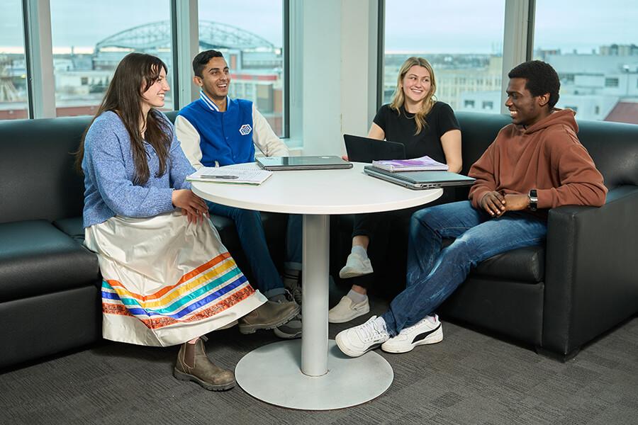 Four students sitting in a student lounge.