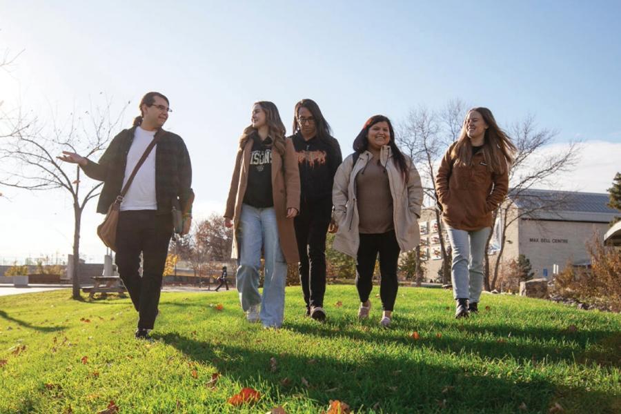 An image of Indigenous students walking together outside on UM's Fort Garry campus on a sunny day
