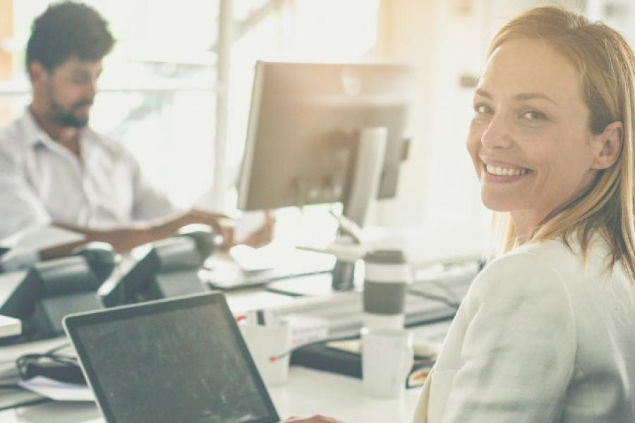 A woman is sitting in front of two other colleagues