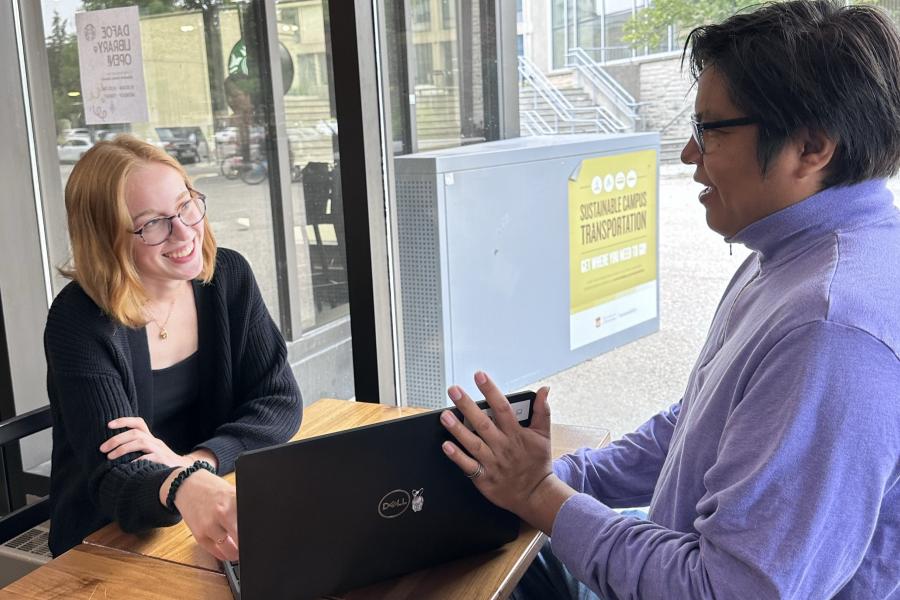 Peer Involvement Advisor showing laptop to student