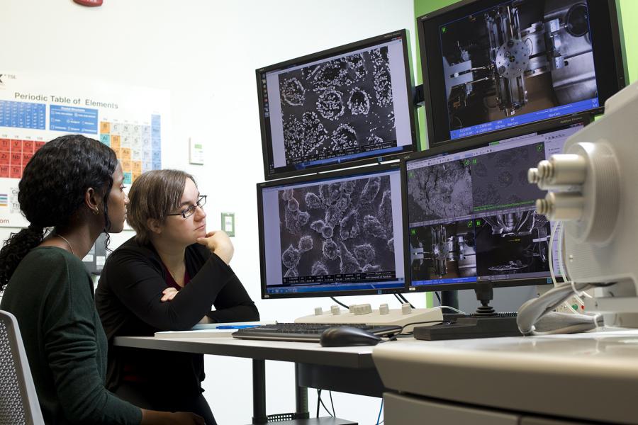 two students studying a variety of computer monitors