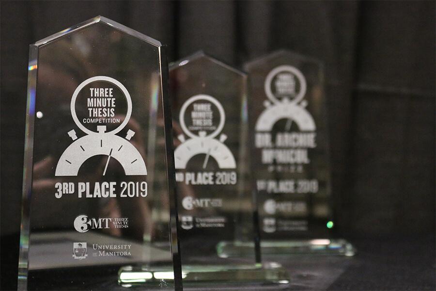 A series of glass awards for the Three Minute Thesis.