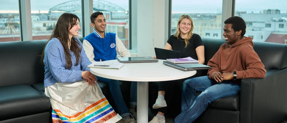 Four students sitting in a student lounge.