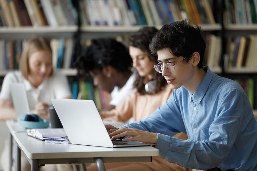 A student is studying on his laptop at the library