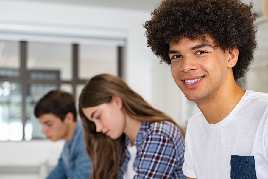 Three students studying and one looking directly into the camera.