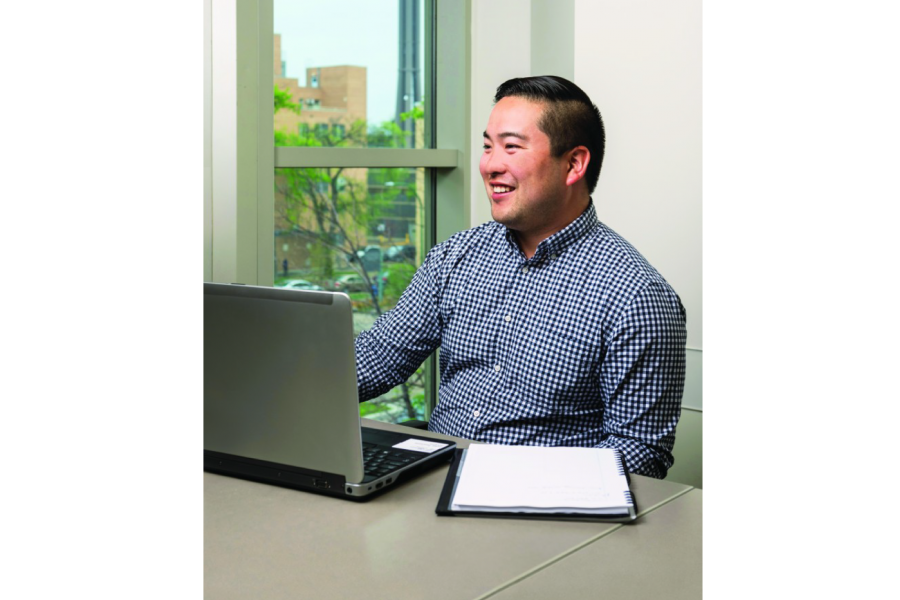 Eliya Ichihashi smiles while working at a laptop.