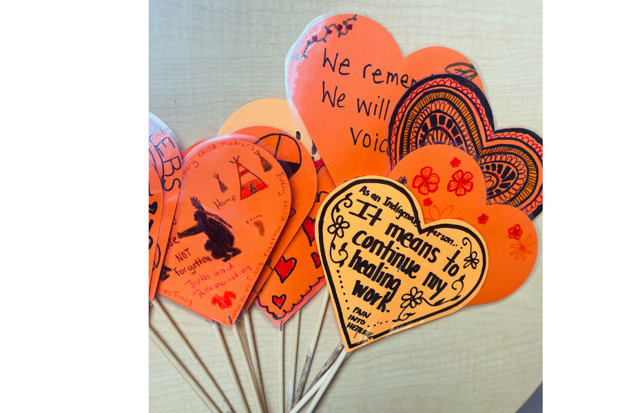 Handmade orange paper hearts with messages honoring Residential School survivors and children who never returned.
