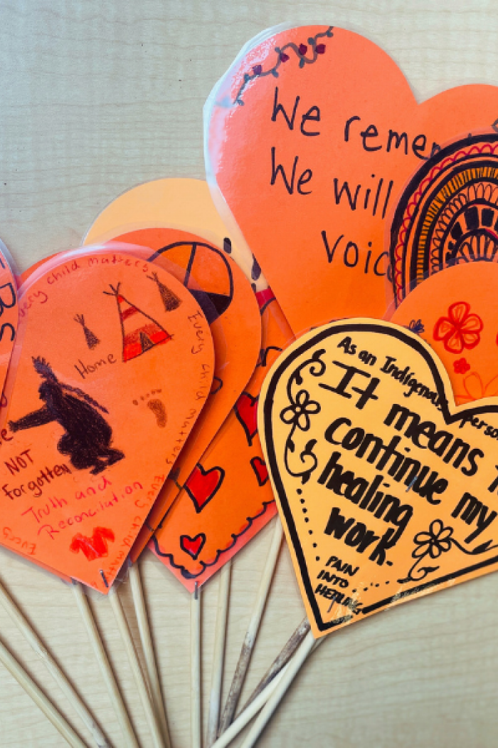 Handmade orange paper hearts with messages honoring Residential School survivors and children who never returned.