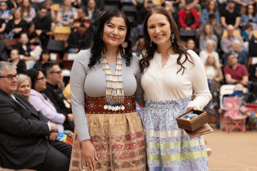 Migizii Agamik Award recipient and presenter at a pow wow ceremony.
