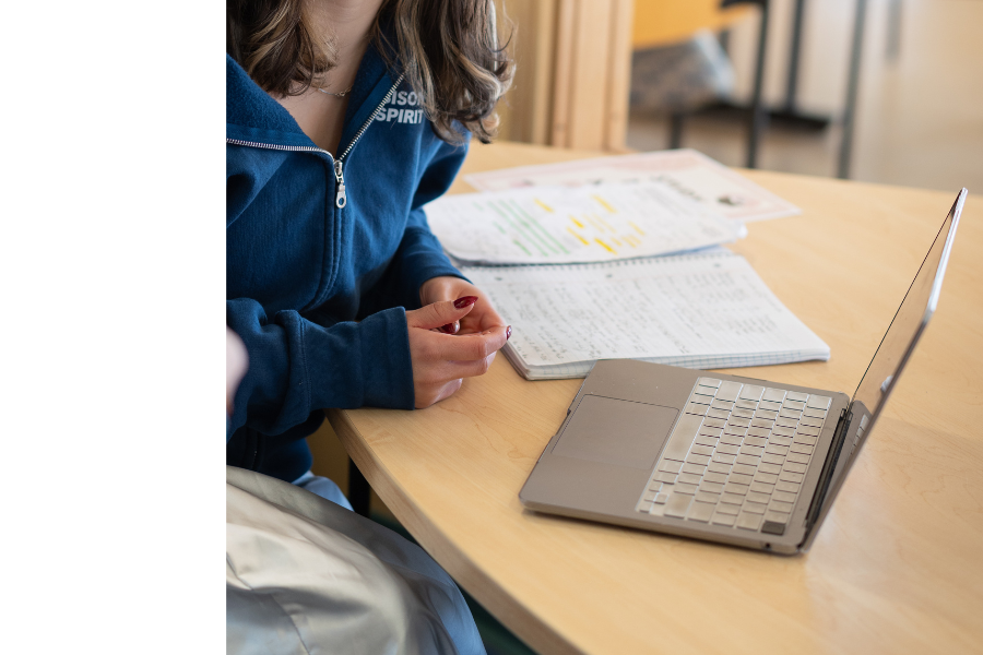 Student studying with a laptop and notebook.