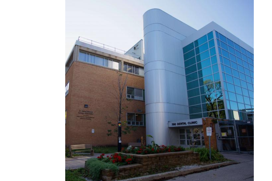 Exterior view of the Rady Faculty of Health Sciences building with “790 Dental Clinic” entrance, trees and flowers along the sidewalk.